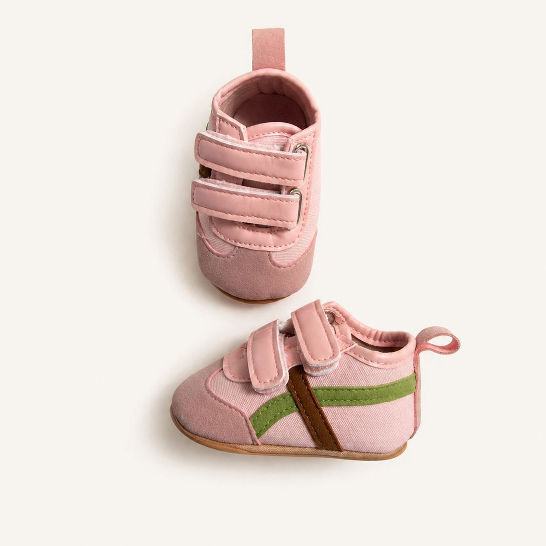 Pair of pink baby shoes with velcro straps on a white background